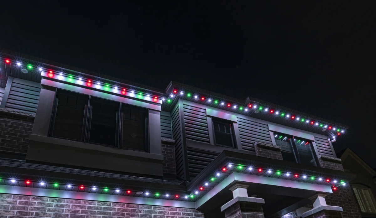 Home eaves lit in red green and white holiday colors